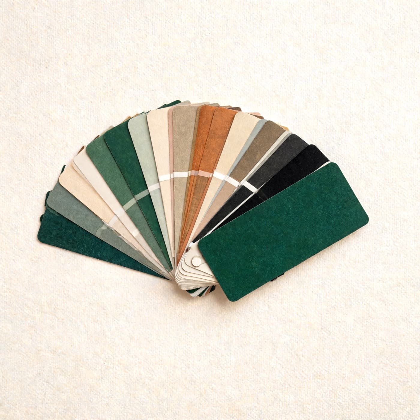 A designer's colour fan opened into an arc, all greens, coppers and warm neutrals.